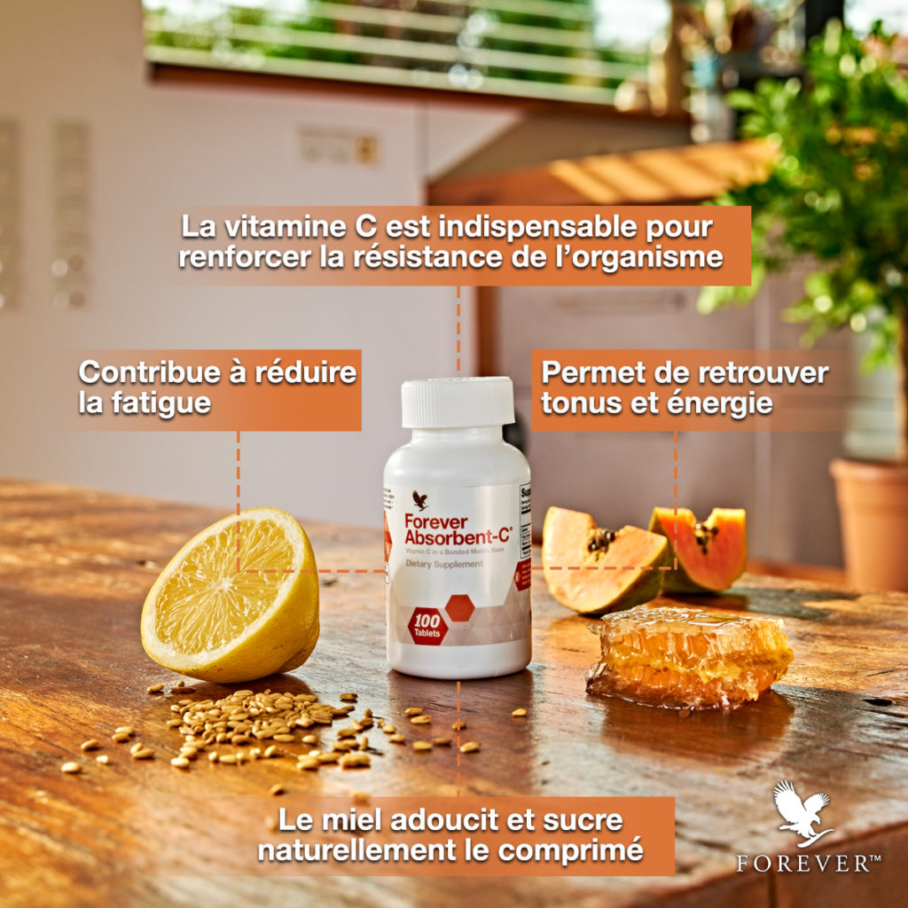 lacon de Forever Absorbent-C sur une table en bois entouré d'un demi-citron, d'une papaye coupée, de miel et de son d'avoine, illustrant ses ingrédients naturels.