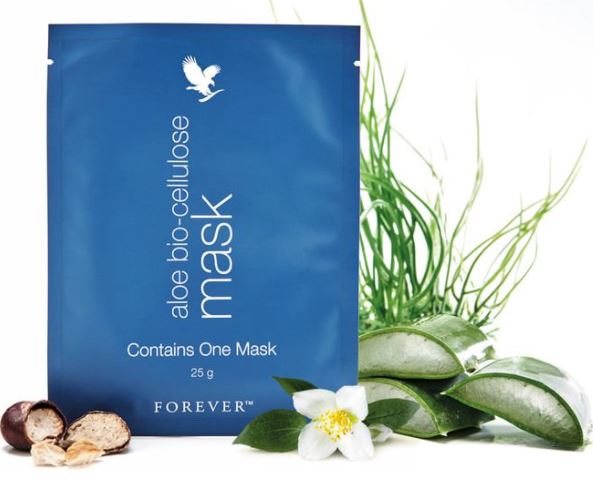 Pochette bleue du masque Aloe Bio-Cellulose de Forever posée à côté de tranches de feuilles d'aloès fraîches et d'une fleur de jasmin blanche sur fond blanc.