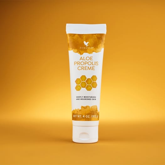 Un tube vertical de crème Aloe Propolis Creme de Forever sur un fond jaune doré dégradé.
