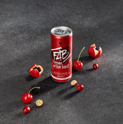 Canette de boisson énergisante FAB Forever Active Boost entourée de fruits de guarana sur un fond sombre.